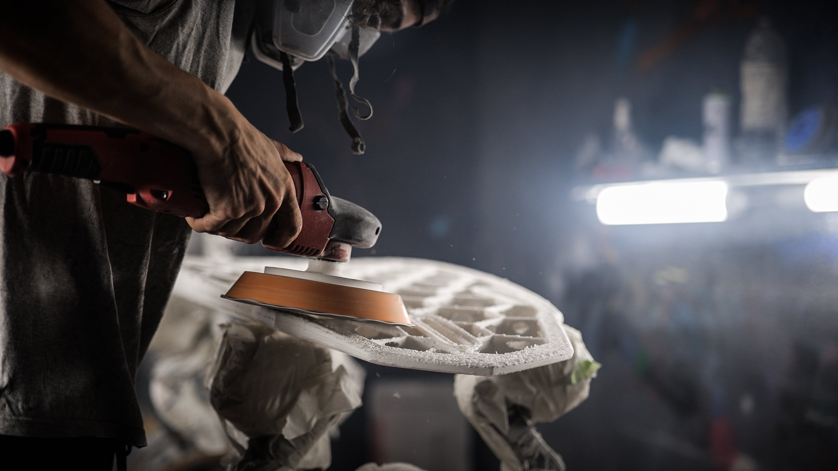 Person shanding a surfboard blank made out of 3D printing