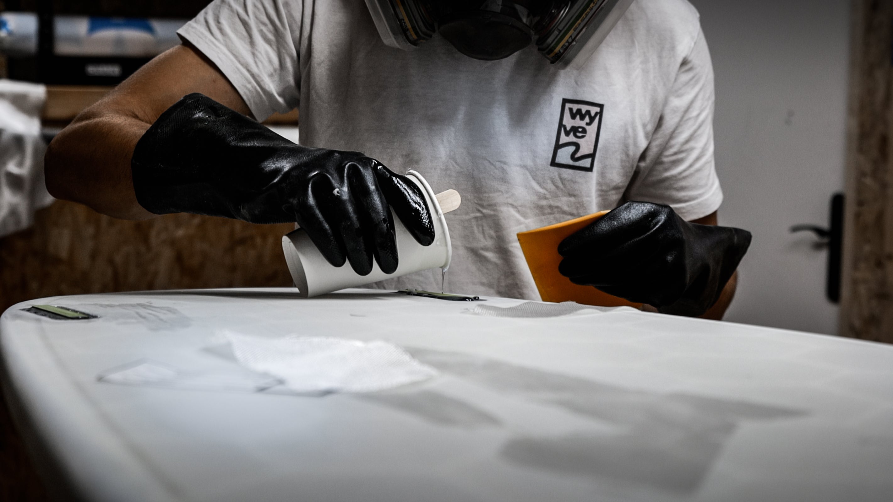 Surf Shaper putting epoxy resin into the bottom of a surfboards
