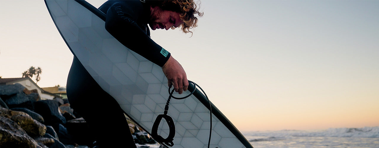 Un surfer avec une planche de surf de la marque française Wyve 