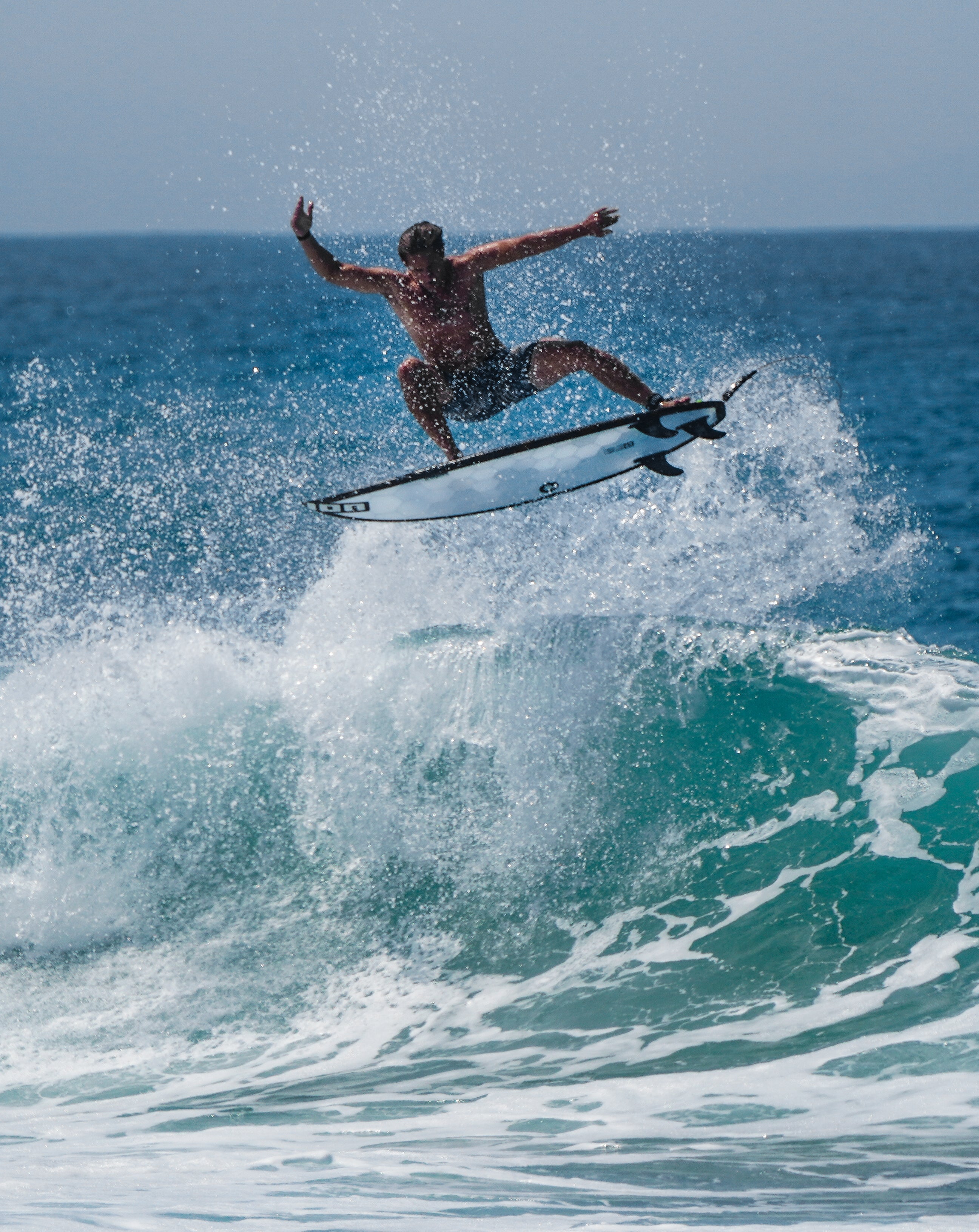 Un surfeur en train de faire un air sur une planche Wyve