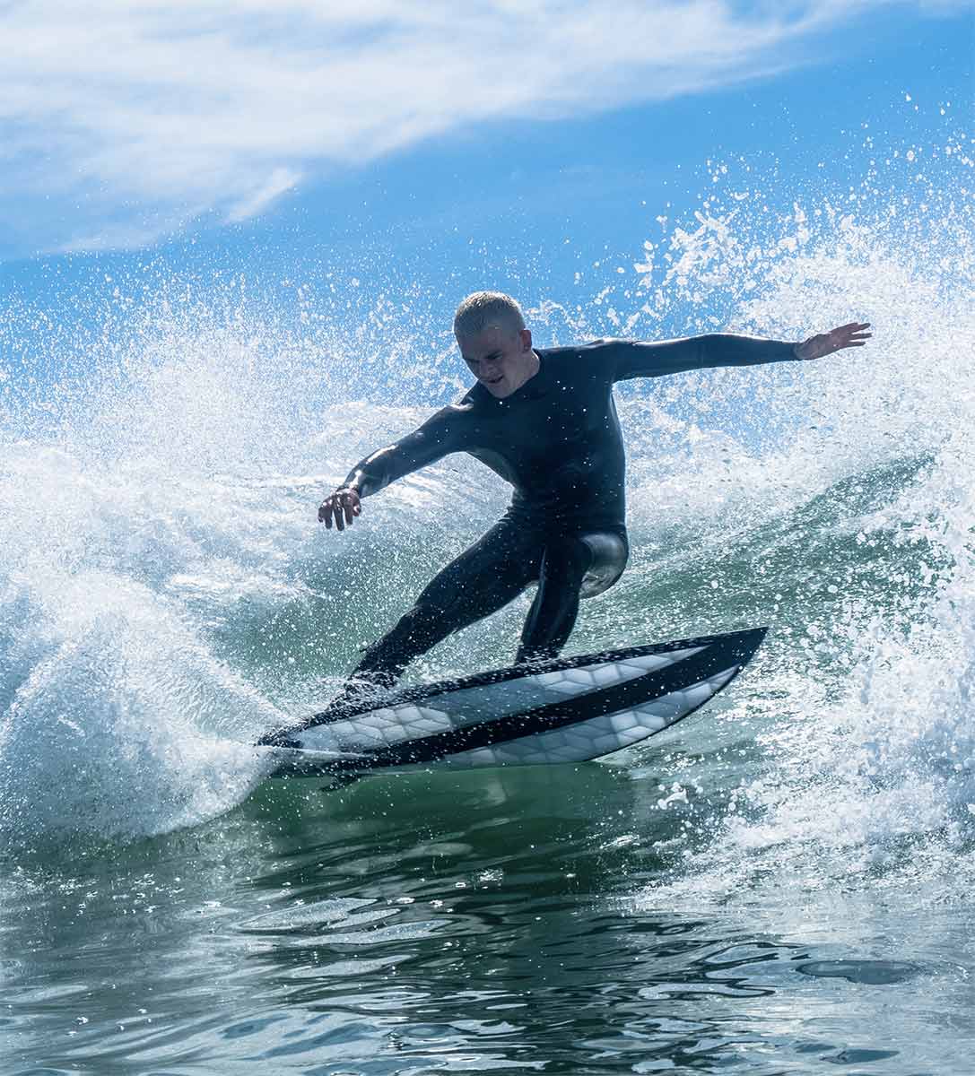 Surfer en train de faire un virage sur une vague avec une planche de surf Wyve 